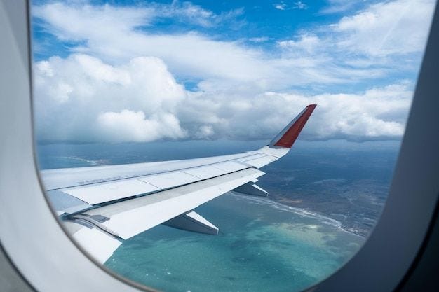 Imagen clásica a través de la ventana del avión en vista de vuelo de ala  sobre el mar en tiempo nublado | Foto Premium